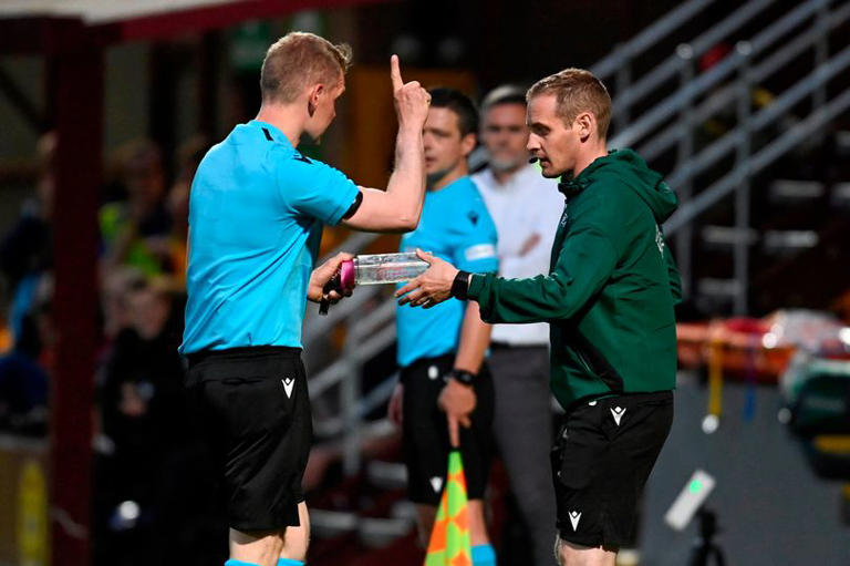 Kári J. á Høvdanum rættir Jóhan Hendriki Ellefsen, fjórða dómara fløskuna, ið var blakað inn á vøllin í Motherwell 